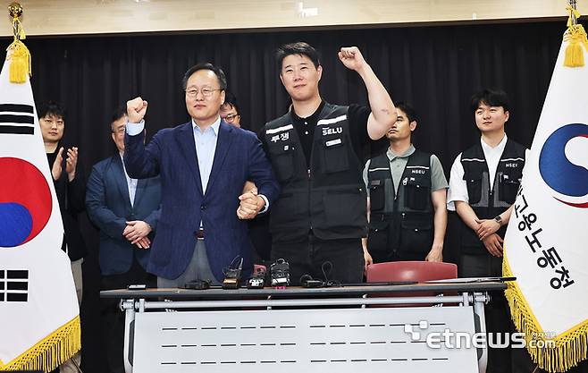 20일 경기도 수원시 장안구 경기고용노동청에서 열린 삼성전자 임금협상을 마친 후 여명구 삼성전자 DS(디바이스솔루션·반도체 사업 담당) 피플팀장과 최승호 삼성그룹 초기업노동조합 삼성전자지부 위원장이 잠정 합의안에 서명한 후 파이팅을 외치고 있다.  연합뉴스