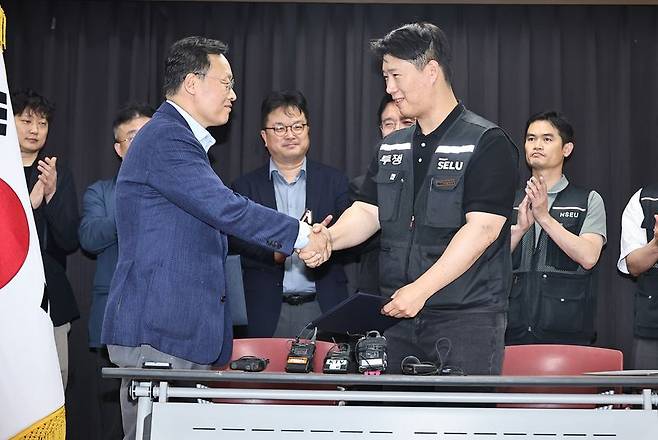 20일 경기도 수원시 장안구 경기고용노동청에서 열린 삼성전자 임금협상을 마친 후 여명구 삼성전자 DS(디바이스솔루션·반도체 사업 담당) 피플팀장과 최승호 삼성그룹 초기업노동조합 삼성전자지부 위원장이 잠정 합의한에 서명한 후 손을 맞잡고 있다. 2026.05.20. /사진=뉴시스