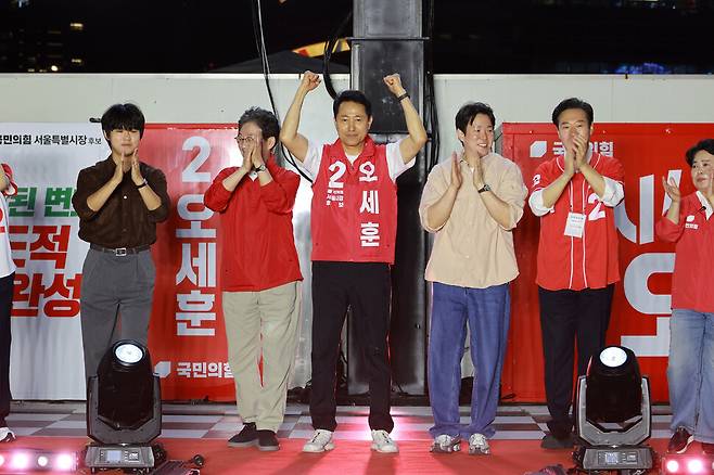 오세훈 국민의힘 서울시장 후보(가운데)가 선거운동 첫날인 21일 서울 중구 청계천광장에서 열린 출정식에서 지지자들을 향해 손을 들 인사하고 있다. 정용일 선임기자