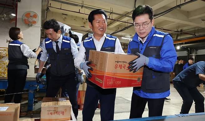 6·3 지방선거 공식 선거운동의 막이 오른 21일 0시 더불어민주당 정원오 서울시장 후보가 정청래 대표, 고민정 의원, 이정헌 의원, 문종철 광진구청장 후보와 함께 서울 광진구 동서울우편집중국을 찾아 택배 업무를 체험하고 있다. 연합뉴스