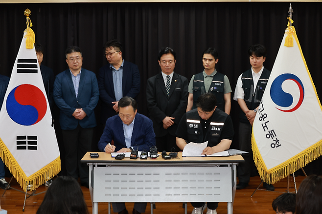 20일 경기도 수원시 장안구 경기고용노동청에서 열린 삼성전자 임금협상을 마친 후 여명구 삼성전자 DS(디바이스솔루션·반도체 사업 담당) 피플팀장과 최승호 삼성그룹 초기업노동조합 삼성전자지부 위원장이 잠정 합의안에 서명하고 있다. [연합뉴스]