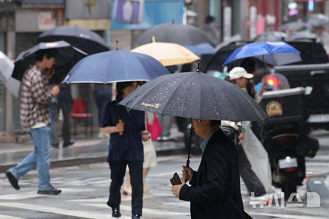 [서울=뉴시스] 권창회 기자 = 비가 내리는 20일 서울 중구 서울시청 인근에서 우산을 쓴 시민들이 우산을 쓰고 이동하고 있다. 2026.05.20. kch0523@newsis.com