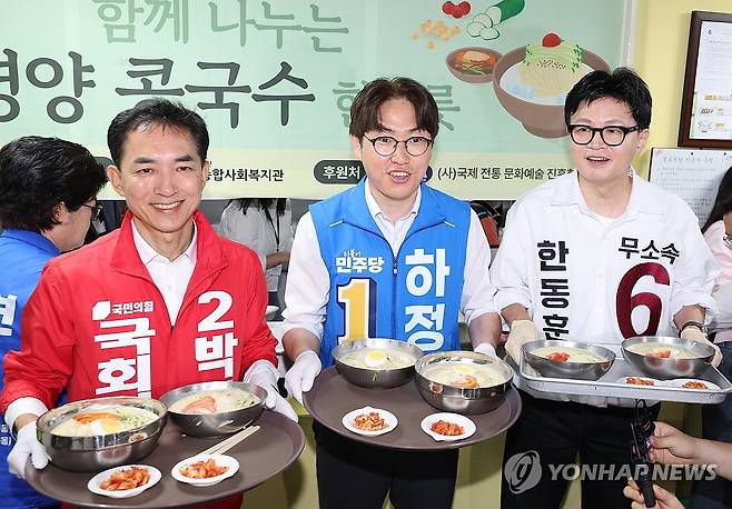 부산 북갑 국회의원 선거 후보, 나란히 배식 봉사 (부산=연합뉴스) 강선배 기자 = 국민의힘 박민식(왼쪽부터), 더불어민주당 하정우, 무소속 한동훈 부산 북구갑 국회의원 보궐선거 후보가 21일 부산 북구 남산정종합사회복지관에서 열린 콩국수 나눔 행사에 참석해 콩국수 배식 봉사를 하고 있다. 2026.5.21 sbkang@yna.co.kr