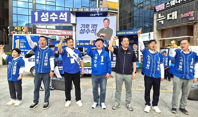 ▲ 지난 21일 열린 이천시 민주당 출정식에서 성수석(사진 중앙) 후보가 지지자들의 환호에 손을 들어 답하는 모습. /사진제공=성수석 선거사무소