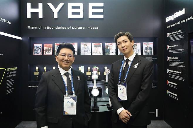 지난해 10월 29일 경주 예술의전당에서 열린 ‘APEC CEO 서밋’ 개회식에서 방시혁(왼쪽) 하이브 의장과 방탄소년단 RM(오른쪽)이 하이브 홍보부스를 관람하고 기념 촬영하고 있다. [연합뉴스]