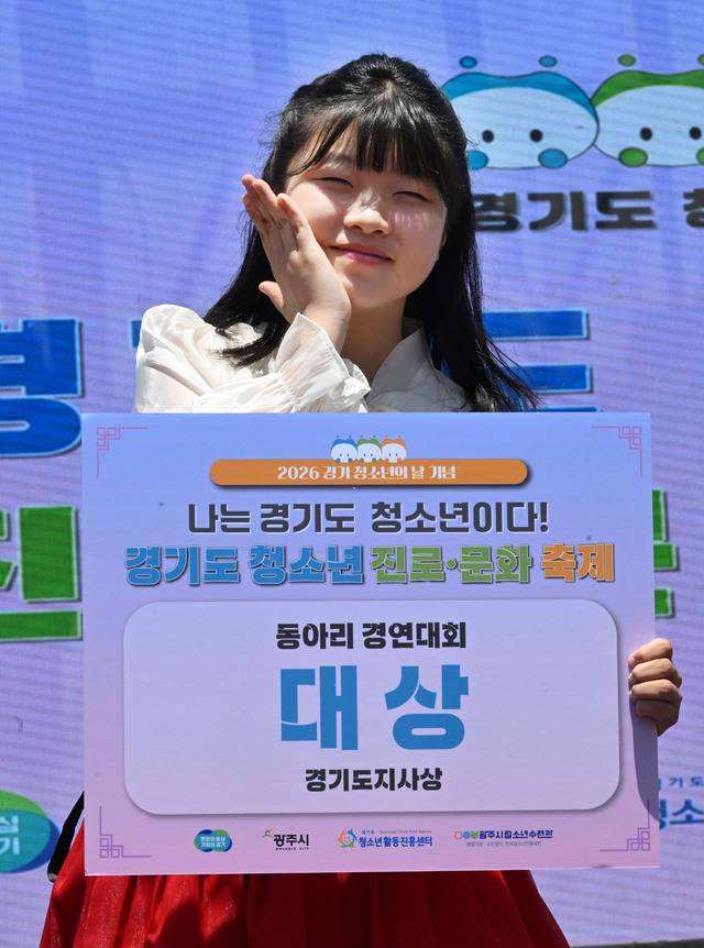 22일 광주시 G-스타디움에서 열린 ‘2026 경기도 청소년 진로·문화 축제’에서 ‘동아리 경연대회’의 보컬부문 대상 수상자인 용인 동백중학교 2학년 김소민양이 수상과 함께 사진촬영을 하고 있다. 김시범기자