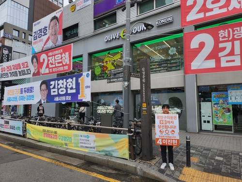 21일 서울 건국대 인근에서 개혁신당의 한 후보가 피켓을 들고 선거 운동을 벌이고 있다. [조병연 기자]