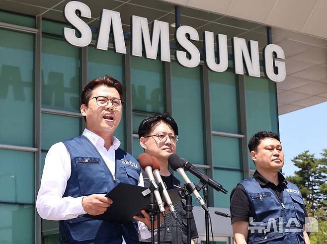 [수원=뉴시스] 김금보 기자 = 삼성전자 디바이스경험(DX) 부문 직원들이 주축인 삼성전자노동조합(SECU·동행노조)과 전국삼성전자노동조합(NSEU) 수원지부 집행부가 22일 오후 경기 수원 영통구 삼성전자 정문 앞에서 삼성전자 노사 임금협상 잠정합의안 찬반 투표 시작을 앞두고 입장을 밝히고 있다. 2026.05.22. kgb@newsis.com
