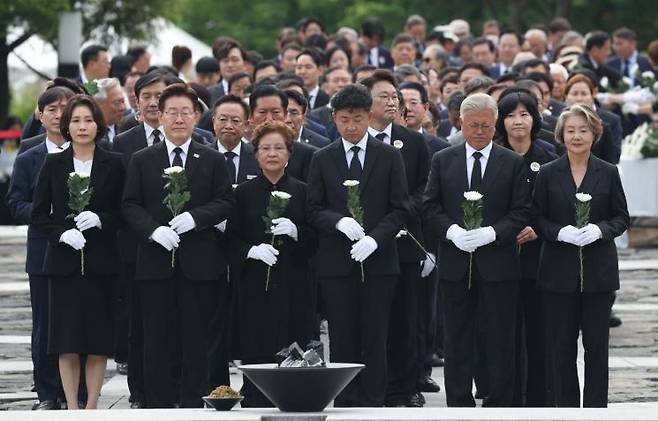 이재명 대통령 부부, 권양숙 여사와 장남 건호 씨, 문재인 전 대통령 부부를 비롯한 참석자들이 23일 경남 김해 봉하마을에서 열린 고 노무현 전 대통령 서거 17주기 추도식에서 국화를 들고 헌화대로 향하고 있다. 2026.5.23 [청와대통신사진기자단] 연합뉴스