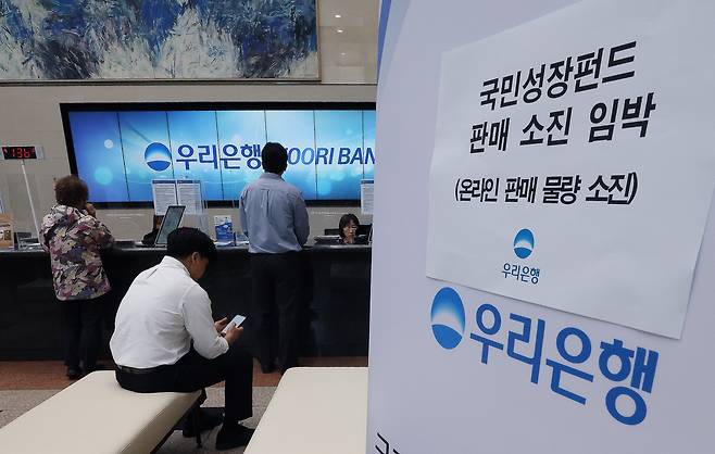 22일 오전 서울 중구 우리은행 본점 영업점에서 고객들이 국민참여형 국민성장펀드에 가입하고 있다. 이날 미래에셋·KB·대신증권 등 주요 증권사와 신한·우리·NH농협은행 등 총 25개 금융회사에서 판매된 1차 물량 소진 조짐을 보이고 있다. / 뉴스1