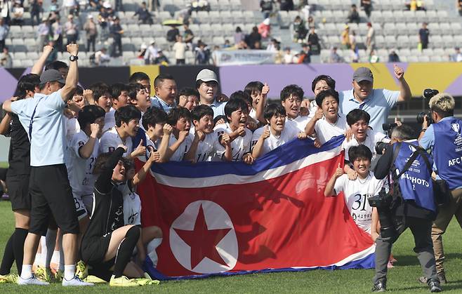 23일 수원종합운동장에서 열린 2025~2026시즌 아시아축구연맹(AFC) 여자 챔피언스리그(AWCL) 결승전에서 도쿄 베르디 벨레자를 1대0으로 꺾고 우승을 차지한 내고향여자축구단 선수들이 인공기를 펼치며 기념촬영을 하고 있다. 뉴시스