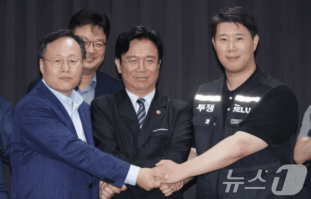 20일 경기도 수원시 장안구 경기고용노동청에서 열린 삼성전자 임금협상을 마친 후 여명구 삼성전자 DS(디바이스솔루션·반도체 사업 담당) 피플팀장과 김영훈 고용노동부 장관, 최승호 삼성그룹 초기업노동조합 삼성전자지부 위원장이 잠정 합의한에 서명한 후 손을 맞잡고 있다. (사진=공동취재, 뉴스1)