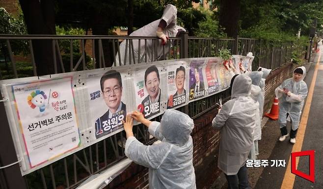 6·3 지방선거 공식 선거운동이 시작된 21일 서울 종로구의 한 거리에서 서울시선거관리 관계자들이 선거벽보를 붙이고 있다. 2026.05.21 윤동주 기자