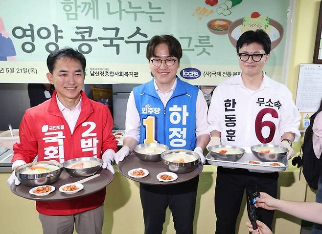 제9회 전국동시지방선거 및 국회의원 재·보궐선거의 공식 선거운동이 시작된 21일 부산 북구갑 국회의원 보궐선거 국민의힘 박민식(왼쪽부터), 더불어민주당 하정우, 무소속 한동훈 후보가 부산 북구 남산정복지관에서 열린 콩국수 나눔행사에서 콩국수를 나르고 있다. ⓒ뉴시스