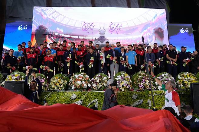 튀르키예에서 열리는 평가전을 위해 출국을 앞둔 이란 축구대표팀 선수들이 13일 이란 테헤란 이슬람혁명광장에서 열린 친정부 성향 집회에서 지지자들의 환영을 받고 있다. 테헤란=AP 뉴시스