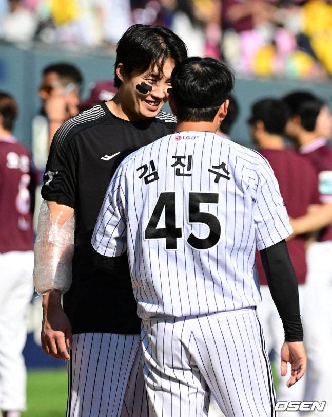 LG 임찬규(왼쪽)가 23일 잠실 키움전 승리 후 자신의 4승을 지켜준 김진수를 향해 미소짓고 있다.