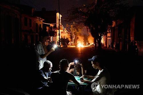 핸드폰 불빛에 의지해 도미노게임을 하는 쿠바인들 [AP=연합뉴스]