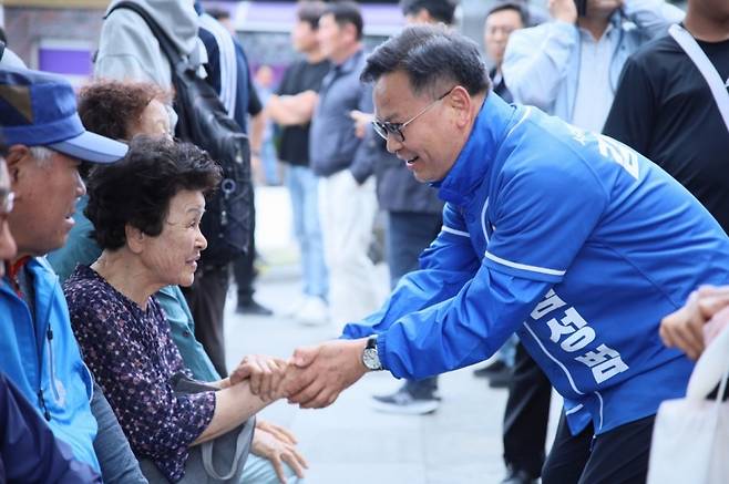 김성범 더불어민주당 국회의원 보궐선거 후보가 지난 24일 서귀포 향토오일시장에서 시민들과 악수를 하며 인사를 하고 있다.