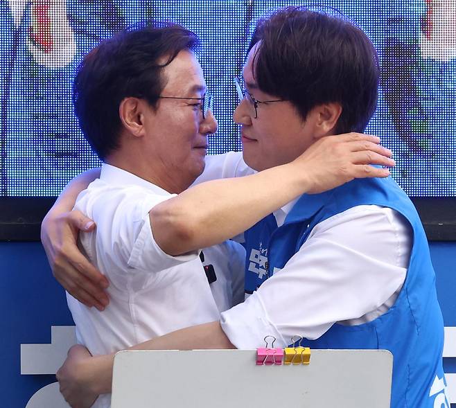 전재수 더불어민주당 부산시장 후보와 하정우 북갑 국회의원 보궐선거 후보가 23일 오후 부산 북구 구포시장 쌈지공원에서 합동유세를 하며 서로 껴안고 있다. 연합뉴스