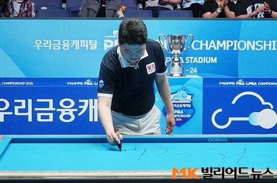 조건휘가 우승한 당구테이블에 사인하고 있다.