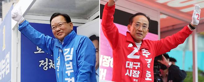 김부겸 더불어민주당 대구시장 후보(왼쪽)와 추경호 국민의힘 대구시장 후보가 지난 21일 대구 범어네거리와 반월당사거리에서 출근길 인사를 하고 있다. [연합뉴스]