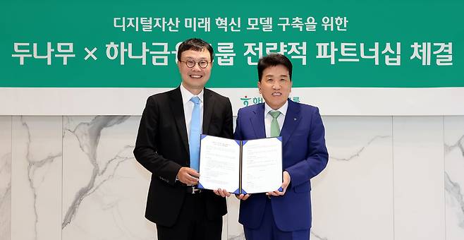 함영주(오른쪽) 하나금융그룹 회장과 김형년 두나무 부회장이 15일 전략적 파트너십 체결 협약식에서 기념촬영을 하고 있다. 하나금융은 이번 협약을 통해 1조원 규모의 두나무 지분을 취득하기로 했다./하나금융 제공