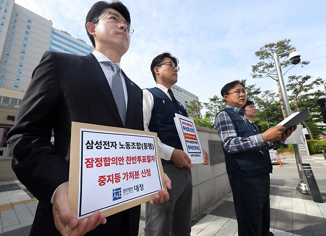 26일 오전 경기 수원시 수원지법 청사 앞에서 삼성전자 디바이스경험(DX) 부문 직원들이 주축이 된 삼성전자 노동조합 동행(동행노조) 집행부가 삼성전자 노사 임금협상 잠정합의안 찬반 투표 중지 등 가처분 신청서를 제출하기 전 취재진의 질문에 답하고 있다. [연합뉴스]
