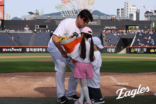 류현진이 24일 통산 200승 기념식에서 자녀로부터 꽃다발을 받고 있다. /사진=한화 이글스