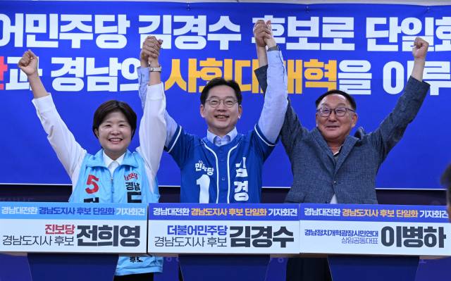 더불어민주당 김경수 경남도지사 후보와 진보당 전희영 경남도지사 후보가 27일 도청 프레스센터에서 후보 단일화를 선언 후 이병하 경남정치개혁광장시민연대 상임공동대표와 손을 들어 인사하고 있다./성승건 기자/