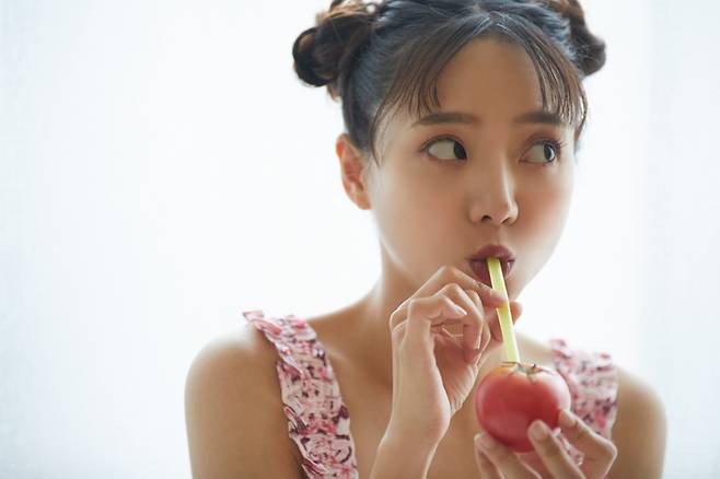 젊은 여성이 토마토에 빨대를 꽂아 마시는 시늉을 하고 있다. 토마토-콩 주스가 비만한 성인의 염증 수치를 줄이는 데 큰 도움이 되는 것으로 나타났다.사진=게티이미지뱅크