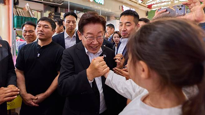 사진은 23일 경남 김해 외동전통시장을 방문한 이재명 대통령이 어린이와 인사하는 모습. [청와대 제공]