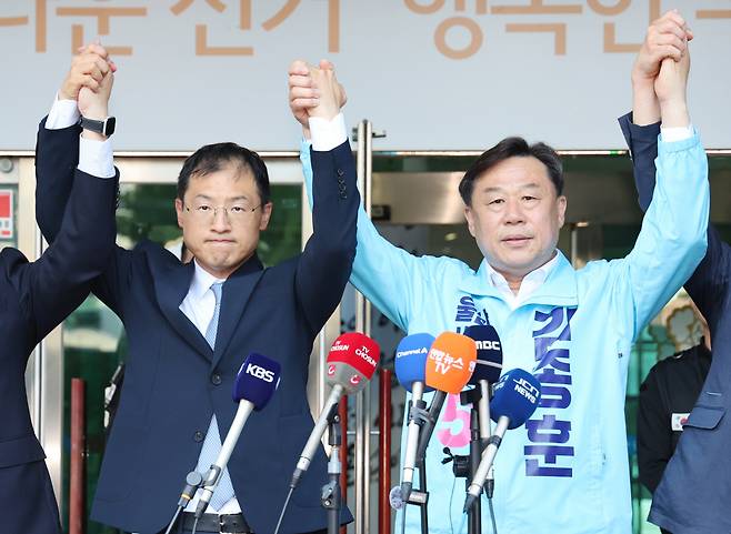 손 맞잡고 승리 다짐하는 김상욱·김종훈 김상욱 더불어민주당 울산시장 후보(왼쪽)와 김종훈 진보당 울산시장 후보가 28일 울산시선거관리위원회 앞에서 김상욱 후보로 단일화한다고 선언한 후 함께 손을 잡고 인사하고 있다. 연합뉴스