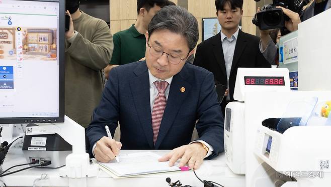 이억원 금융위원장이 지난 22일 오전 서울 종로구 NH농협은행 정부서울청사지점에서 국민참여성장펀드에 가입하고 있다. 윤창빈 기자