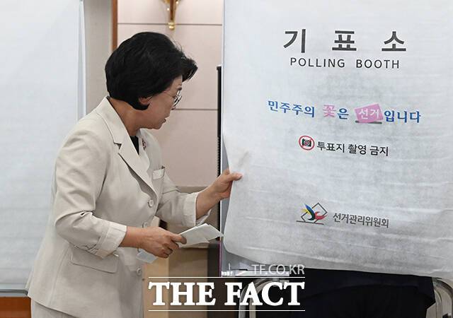 김부겸 더불어민주당 대구시장 후보의 부인 이유미 여사가 제9회 전국동시지방선거 사전투표 날인 29일 오전 대구 수성구 고산2동 행정복지센터에 마련된 사전투표소에서 김부겸 후보의 기표소를 열어보고 있다. /대구=박헌우 기자