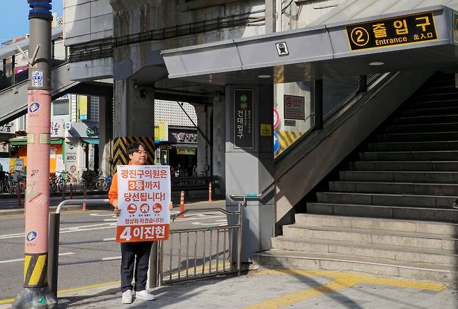 이진현 개혁신당 서울 광진구의원 후보가 25일 오전 건대입구역 2번 출구 앞에서 팻말을 들고 선거운동을 하고 있다.