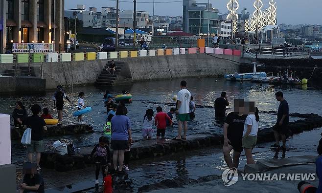제주 용천수 물놀이로 열대야 식혀요 지난해 7월 3일 오후 제주시 삼양동 용천수 '샛도리물'을 찾은 피서객들이 물놀이하며 밤더위를 식히고 있다. 2025.7.3 koss@yna.co.kr [연합뉴스 자료사진]