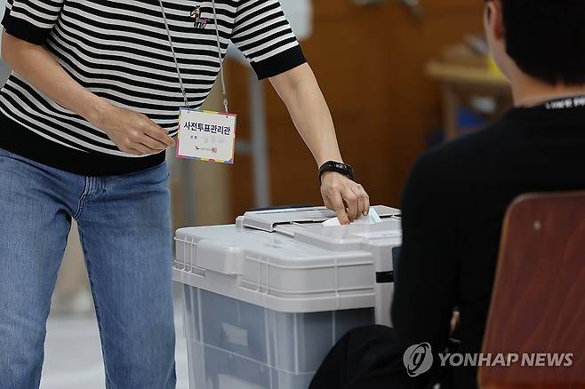 투표 관리관도 한 표 행사 (울산=연합뉴스) 장지현 기자 = 6·3 지방선거 및 국회의원 재·보궐선거 사전투표 첫날인 29일 오전 울산 남구 신정2동 행정복지센터에 마련된 사전투표소의 한 사전투표 관리관이 기표한 투표지를 투표함에 넣고 있다. 2026.5.29 jjang23@yna.co.kr
