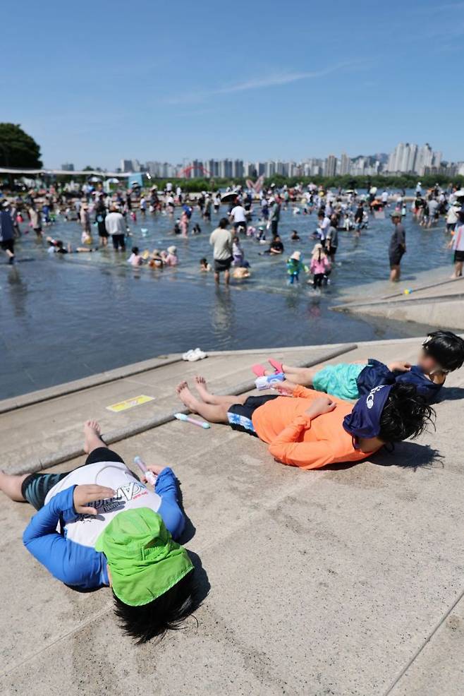 전국이 맑은 가운데 기온이 전날보다 오르면서 더운 날씨를 보인 31일 서울 영등포구 여의도물빛광장에서 시민들이 물놀이를 즐기고 있다. 2026.5.31 연합뉴스