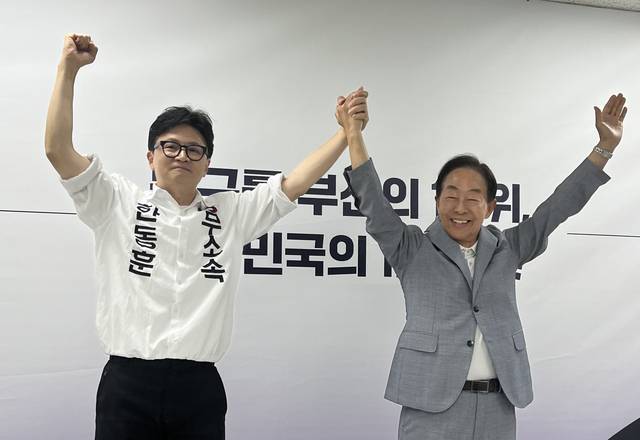 김영삼(YS) 전 대통령 차남인 김현철 김영삼 대통령기념재단 이사장(오른쪽)이 23일 오후 부산 북갑 국회의원 보궐선거에 출마한 무소속 한동훈 후보(왼쪽) 선거캠프에서 지지를 선언하는 기자회견을 한 뒤 만세하고 있다. [연합뉴스]