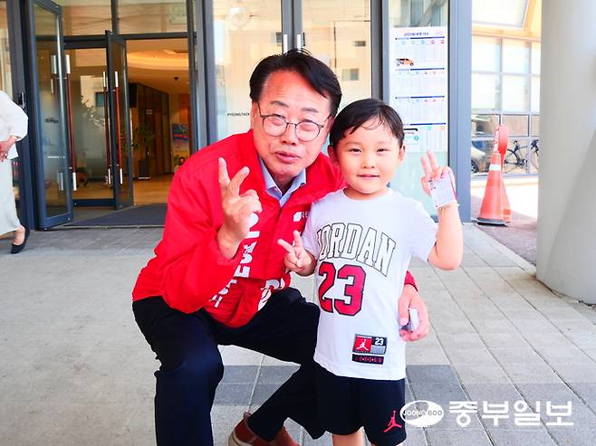 차화열 평택시장 후보가 지난 31일 제일감리교회에서 한 어린이에게 명함을 건넨 뒤 손가락으로 기호 2번을 뜻하는 V자를 만들어 보인다. 조미림 기자