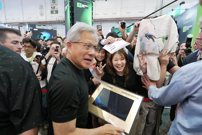 삼성디스플레이가 대만 타이베이 난강 전시장을 방문한 젠슨 황으로부터 노트북용 14형 OLED 패널에 사인을 받는 모습.(사진=공동취재단)