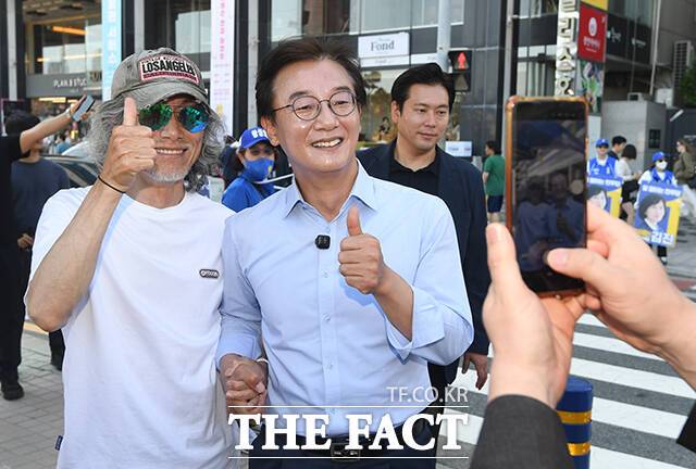 전재수 더불어민주당 부산시장 후보(가운데)가 지난달 31일 오후 부산 수영구 광안리 만남의광장 인근에서 한 시민과 사진을 찍고 있다. /부산=박상민 기자