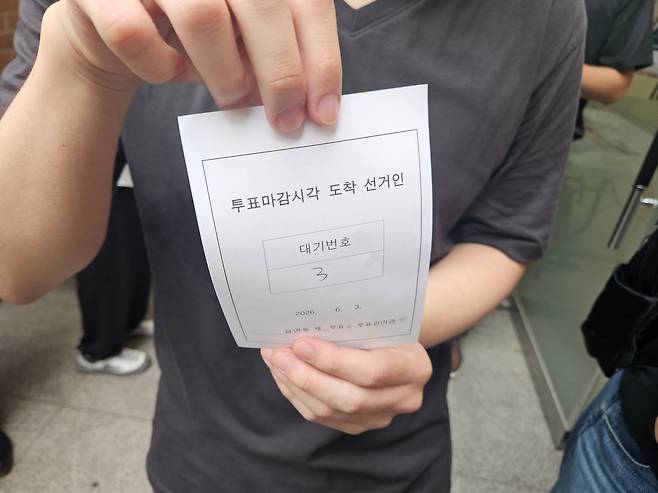 한 시민이 3일 오후 6시 잠실2동 잠일초등학교 투표소 앞에서 대기표를 보여주고 있다. 이날 이 투표소에는 투표용지 부족으로 유권자 150여명이 제 시간에 투표하지 못하고 대기하는 일이 벌어졌다./원종빈 기자