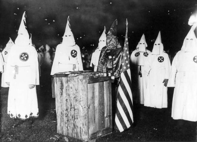 1920년 미 시카고에서 벌어진 집회에서 ‘KKK’의 상징인 가운과 고깔모자 차림을 한 회원들. /위키피디아