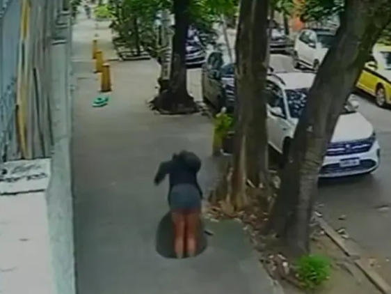 브라질 리우데자네이루의 길거리를 걷고 있던 여성이 주차된 차량들 옆 인도에 있는 맨홀 속으로 빠지는 모습. [뉴욕포스트 캡처]