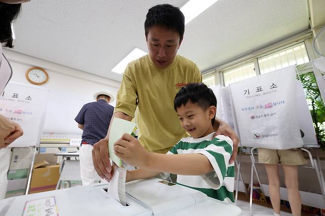 김명진(7)군이 아빠와 함께 제9회 전국동시지방선거 본투표일인 3일 오전 서울 서초구 서래초등학교에 마련된 방배본동제2투표소에서 투표를 체험하고 있다. 김영원 기자 forever@hani.co.kr