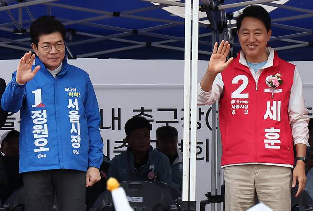지난달 3일 정원오 더불어민주당 서울시장 후보(왼쪽), 오세훈 국민의힘 서울시장 후보가 서울 효창운동장에서 열린 제44회 서울특별시장기 축구대회 개회식에서 선수들을 향해 손을 흔들고 있다. [연합]