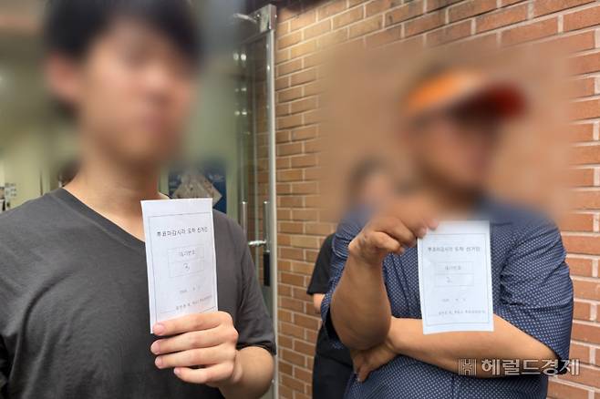 3일 오후 6시10분께 서울 송파구 잠실2동 제6투표소에서 유권자들이 ‘투표마감시각 도착 선거인’ 대기표를 들고 취재진을 향해 보여주고 있다. 윤승현 수습기자.