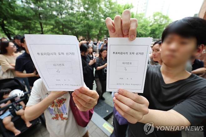 용지부족 투표 중지에 투표 대기번호표 든 유권자 (서울=연합뉴스) 김주형 기자 = 6·3 지방선거 본투표일인 3일 서울 송파구 잠실2동 6투표소에서 투표용지 부족으로 대기하던 한 유권자가 마감시간 후 대기번호표를 들어 보이고 있다. 2026.6.3 kjhpress@yna.co.kr