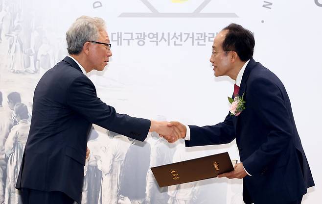 제9회 전국동시지방선거 당선인에 대한 당선증 교부식이 4일 오후 대구시선관위 강당에서 열렸다. 강동명 대구시선관위원장(왼쪽)이 추경호 대구시장 당선인에게 당선증을 전달하고 있다. /이용선기자 photokid@kbmaeil.com